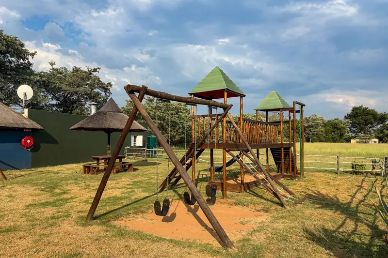 A wooden climbing frame on a sunny playground lawn